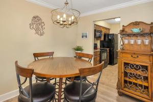 eine Küche und ein Esszimmer mit einem Holztisch und Stühlen in der Unterkunft Island Retreat #2513-2 in Island Retreat