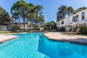 einen Pool mit Stühlen neben einem Gebäude in der Unterkunft Island Retreat #2513-2 in Island Retreat