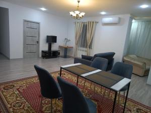 ein Wohnzimmer mit Tisch, Stühlen und Sofa in der Unterkunft Apartment NEW in Taschkent