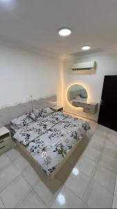 una camera da letto con un letto e uno specchio sul muro di شاليه أمسية a Buraydah