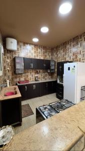 una cucina con armadi neri e frigorifero bianco di شاليه أمسية a Buraydah