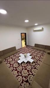una camera con divano e tavolo su un tappeto di شاليه أمسية a Buraydah