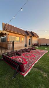 un tappeto steso sull'erba davanti a una casa di شاليه أمسية a Buraydah