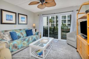 a living room with a couch and a tv at Beach Club #107 in Saint Simons Island
