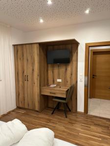 a bedroom with a desk and a television on a wall at Haus Levi in Imst