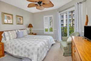 a bedroom with a bed and a ceiling fan at Beach Club #107 in Saint Simons Island +19 photos