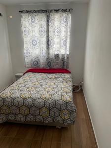 a bedroom with a bed with a curtain and a window at Decoradinho RJ in Rio de Janeiro +2 photos