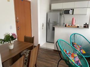 a kitchen with a table and chairs and a refrigerator at Decoradinho RJ in Rio de Janeiro