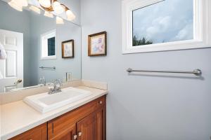 a bathroom with a sink and a mirror at 26 Coast - Shellbar Cottage in East End +26 photos