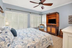 a bedroom with a bed and a flat screen tv at 26 Coast - Shellbar Cottage in East End