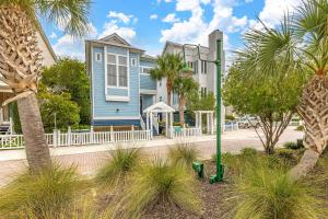 a blue house with palm trees and a street light at 26 Coast - Shellbar Cottage in East End