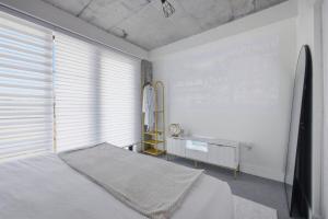 ein weißes Schlafzimmer mit einem Bett und einem Fenster in der Unterkunft Modern Luxe 2BR Escape, City Views, 1 stop to NYC in Newark