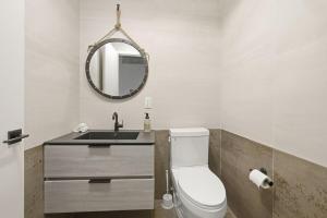 ein Badezimmer mit Toilette und Spiegel in der Unterkunft Modern Luxe 2BR Escape, City Views, 1 stop to NYC in Newark