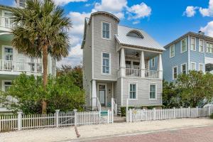 ein Haus mit einem weißen Zaun und einer Palme in der Unterkunft 16 Coast - Merrimac Cottage in East End