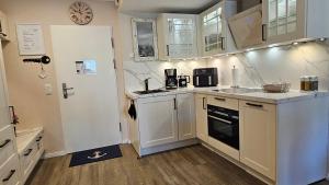 a kitchen with white cabinets and a stove top oven at Valencia Am Rosenhof in Kühlungsborn