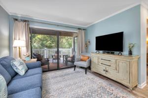 a living room with a couch and a television at Shipwatch #106 in East End