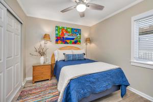 a bedroom with a bed and a ceiling fan at Shipwatch #106 in East End +20 photos