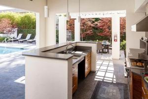 cocina con fregadero y patio con piscina en Cupertino 2BR w Pool BBQ Gym nr Shopping SFO-374, en Cupertino