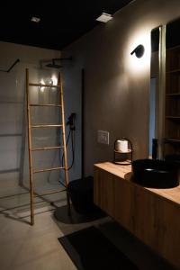 een badkamer met een zwarte wastafel en een ladder bij Trihouse Douro and Sea View in Vila Nova de Gaia