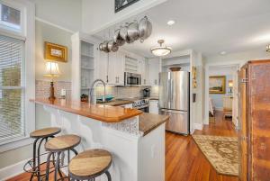 een keuken met een aanrecht en twee krukken erin bij 27 Coast - Frederica Cottage in East End