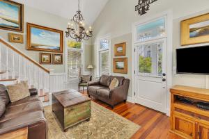 een woonkamer met een bank en een tv bij 27 Coast - Frederica Cottage in East End