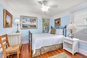 een slaapkamer met een bed, een stoel en een raam bij 27 Coast - Frederica Cottage in East End +22 foto's