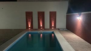 ビヤ・ドロレスにあるComplejo LUMAの壁に照明が付いた客室内のスイミングプール