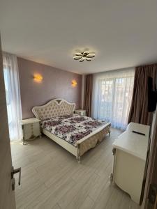 een slaapkamer met een bed en een plafondventilator bij Sarah Apartment in Constanţa