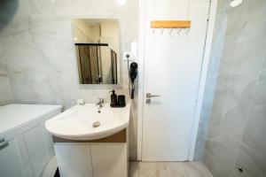 a white bathroom with a sink and a mirror at Central Gem Tirana in Tirana +29 photos