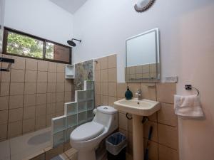 a bathroom with a toilet and a sink and a mirror at Hotel Manuel Antonio Inn in Quepos +41 photos