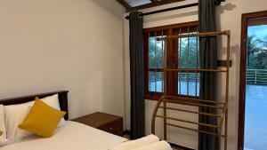een slaapkamer met een bed met een geel kussen en een ladder bij Villa A7 in Ahangama
