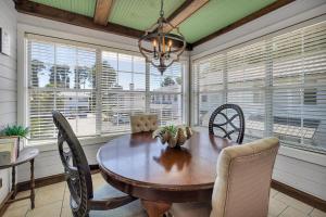 una sala da pranzo con tavolo, sedie e finestre di Island Square #808 a Island Retreat