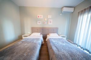 a bedroom with two beds and a window at Central Gem Tirana in Tirana