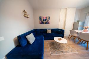a living room with a blue couch and a table at Central Gem Tirana in Tirana