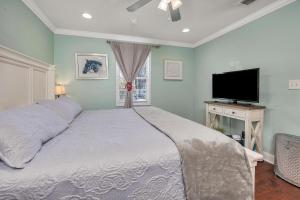 una camera da letto con un letto e una TV a schermo piatto di Island Square #808 a Island Retreat Altre 25 foto