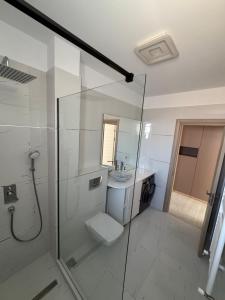 een badkamer met een douche, toilet en wastafel bij Sarah Apartment in Constanţa