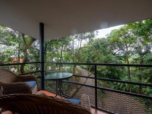 a balcony with a table and chairs and trees at Hotel Manuel Antonio Inn in Quepos
