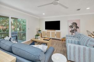 a living room with two blue couches and a flat screen tv at Demere Landing #162 in Saint Simons Island