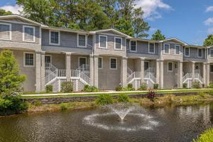 a building with a fountain in the middle of a pond at Demere Landing #162 in Saint Simons Island