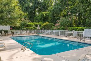 a swimming pool with chairs and a fence at Demere Landing #162 in Saint Simons Island