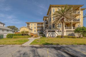 een gebouw met een palmboom voor een parkeerplaats bij Sea Gate #104 in Demere Park