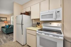 a kitchen with a white refrigerator and a microwave at 1055 College in Saint Simons Island