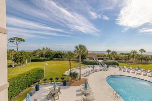 a view of a pool and chairs and a resort at Beach Club #211 in East End