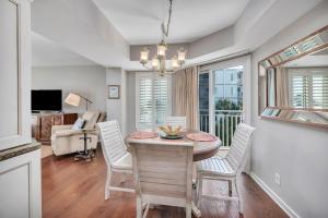 a kitchen and dining room with a table and chairs at Beach Club #211 in East End