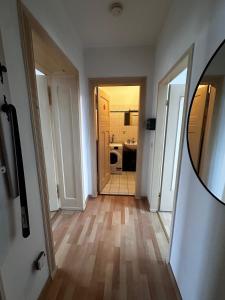 2-Zi-Wohnung und Parkplatz für Geschäftsreisende في رودرسدورف: ممر به مرآة وحمام