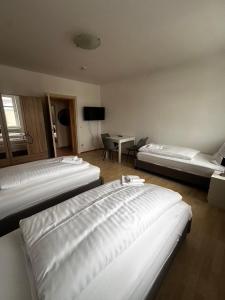 2-Zi-Wohnung und Parkplatz für Geschäftsreisende في رودرسدورف: غرفة بسريرين وطاولة مع تلفزيون