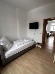 2-Zi-Wohnung und Parkplatz für Geschäftsreisende في رودرسدورف: غرفة معيشة مع أريكة وتلفزيون بشاشة مسطحة +صورتان