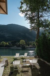 three chairs and a table with a view of a lake at La Presentosa guest house in Villalago