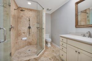 a bathroom with a shower and a sink and a toilet at 545 Beachview Dr in Saint Simons +27 photos