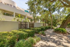 a house with a fence and trees and a sidewalk at 545 Beachview Dr in Saint Simons